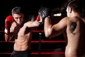 Latin boxer and his coach doing some sparring in the ring